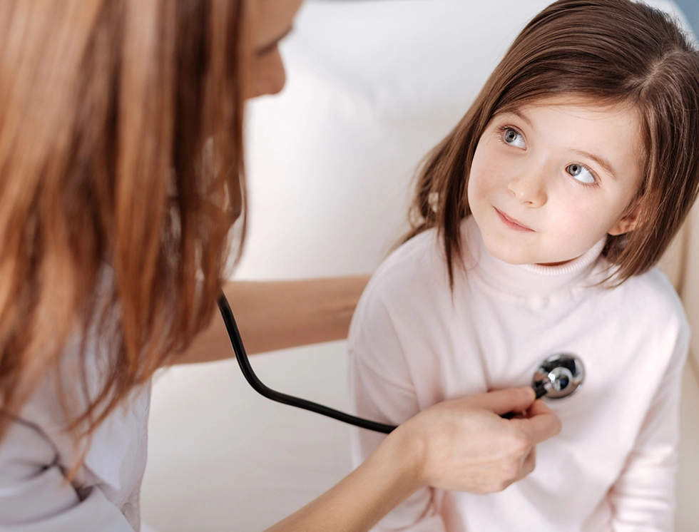 A compassionate doctor gently examines a young girl using a stethoscope